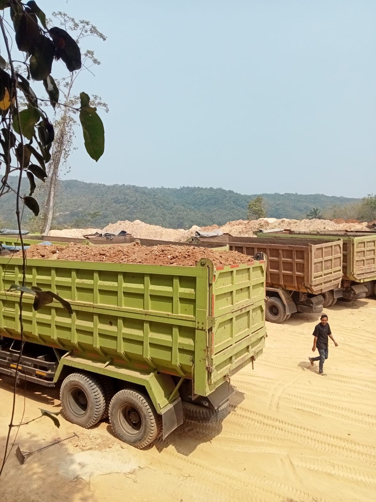 Armada dump truck bermuatan material